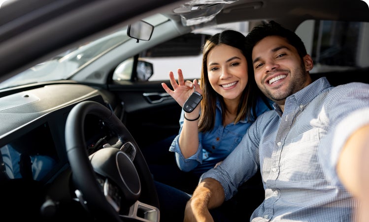 Couple holding keys to their new vehicle